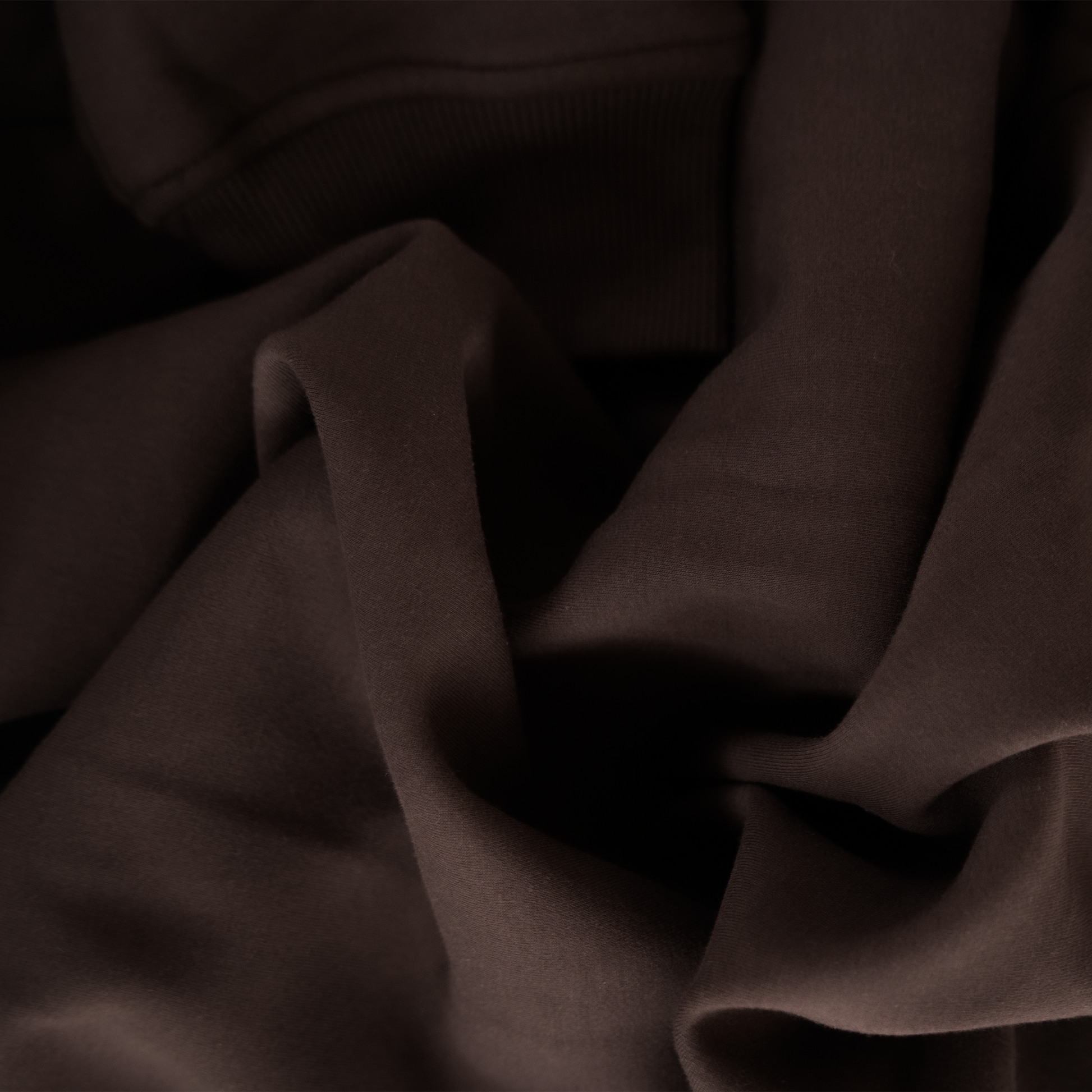 Close-up of dark brown fabric with folds