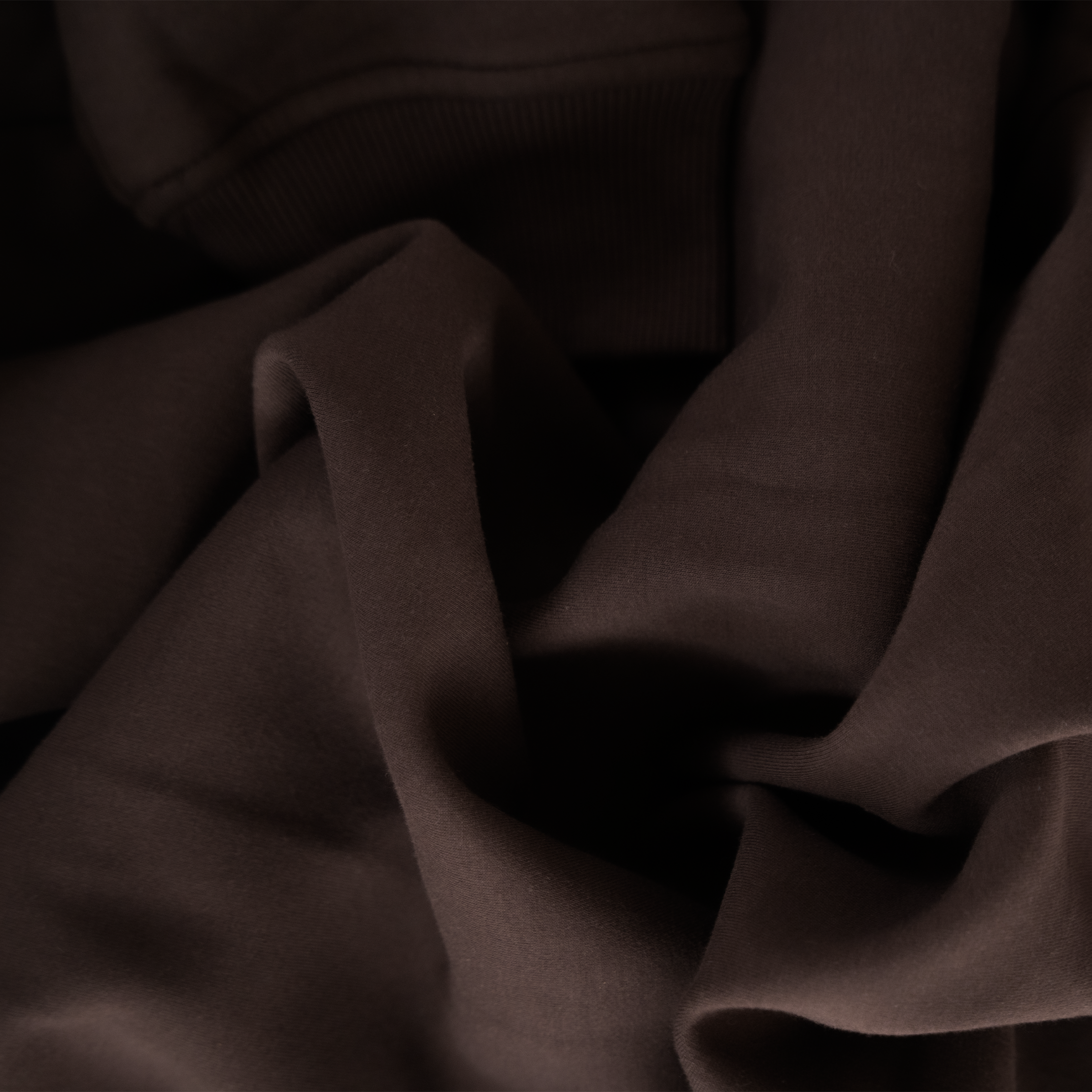 Close-up of dark brown fabric with folds