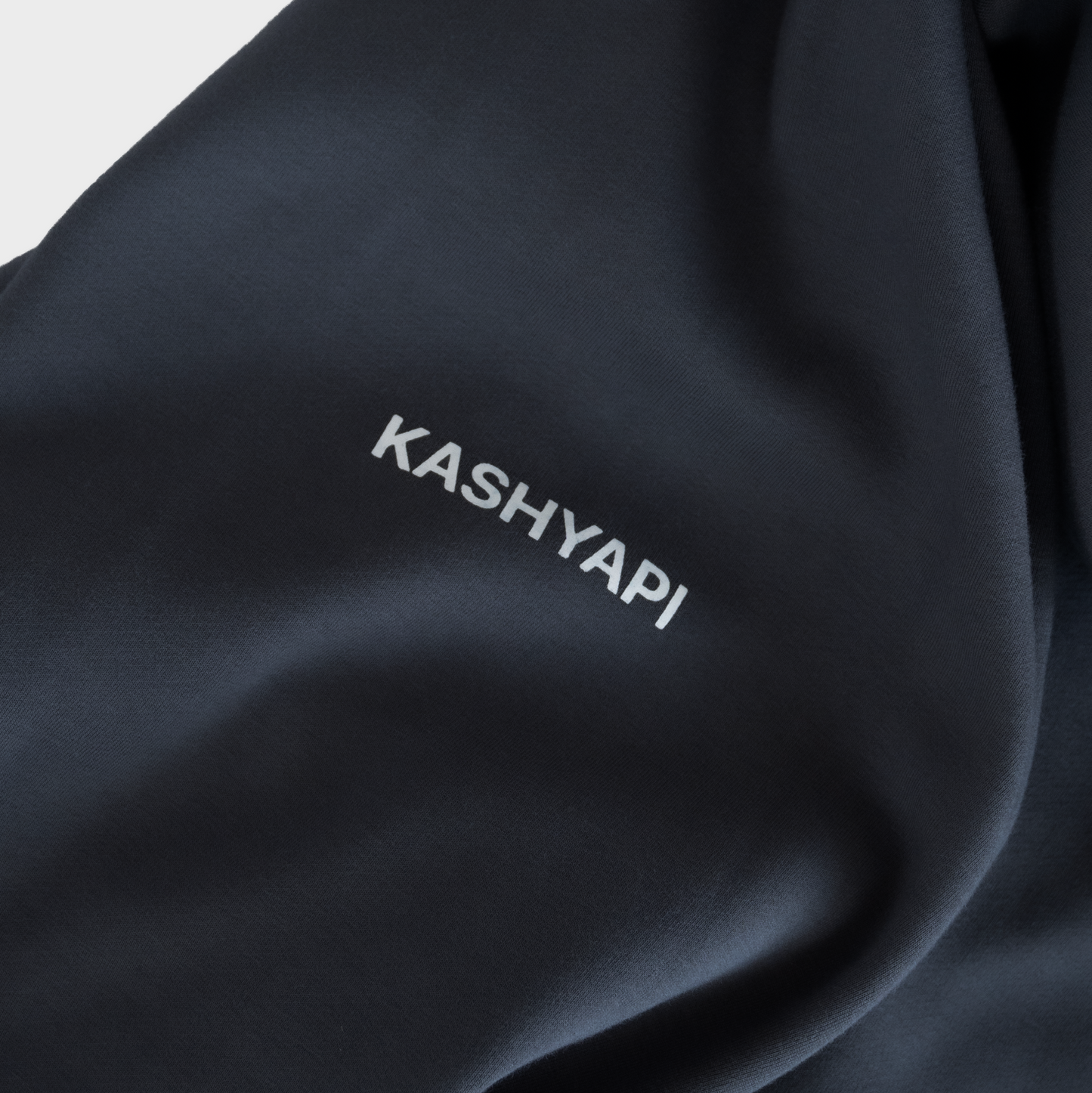 Black fabric with 'KASHYAP' embroidery on a white background